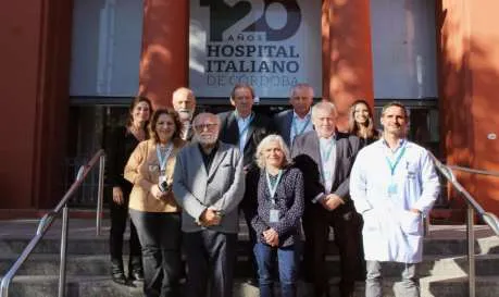 Equipo del CENAS y del Hospital Italiano de Córdoba en la entrada del hospital, junto al cartel de sus 120 años